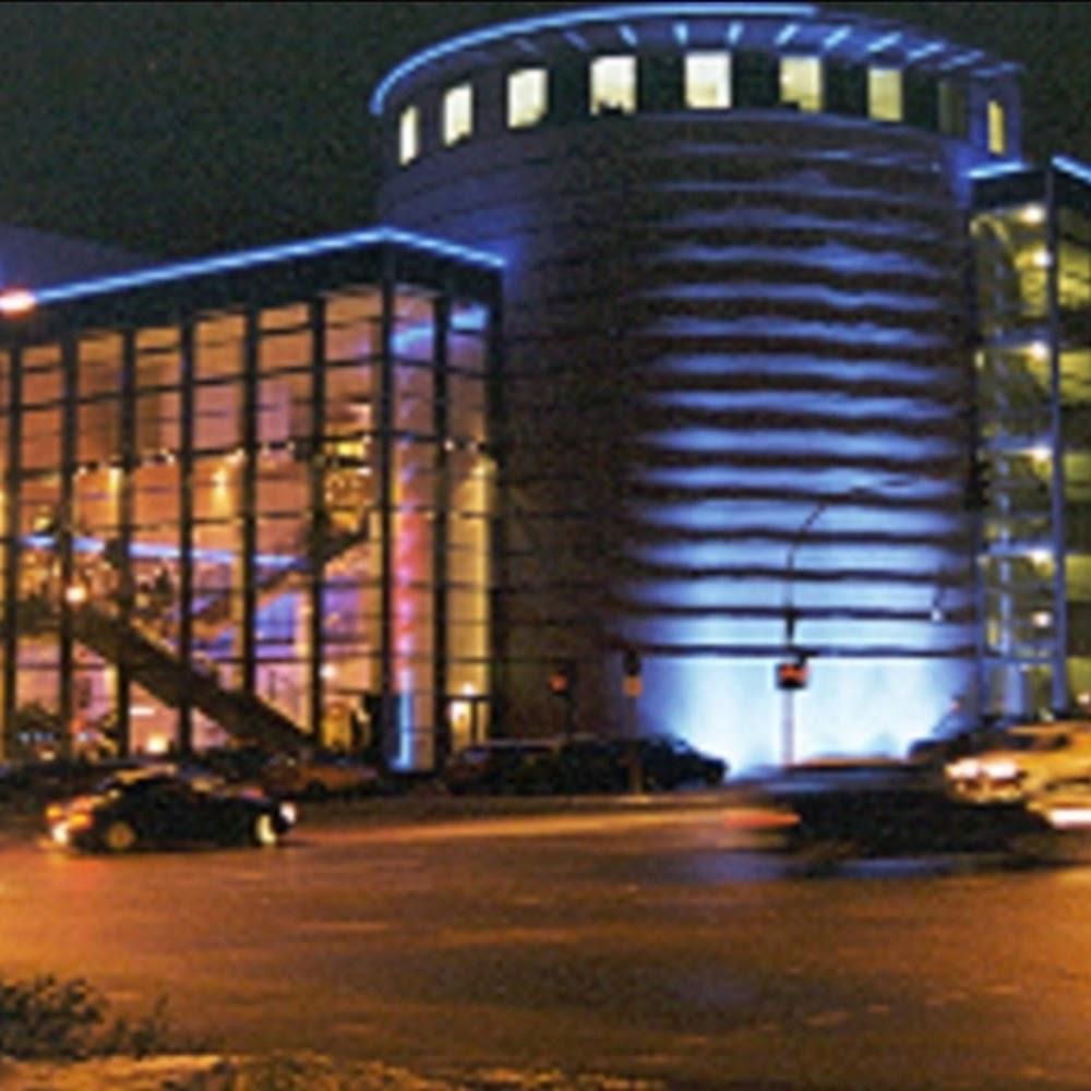 A modern building with blue lighting at night.